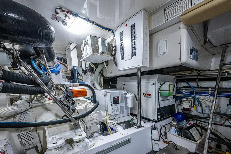 Slide: The Image of Engine room of 2008 Hatteras 60 GT yacht, featuring Onan generator and control panels. - 49