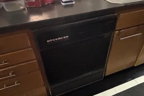 Slide: The Image of Kitchen with black dishwasher, wooden cabinets, and countertop on a 1991 Florida Bay Coasters 53 Trawler. - 11