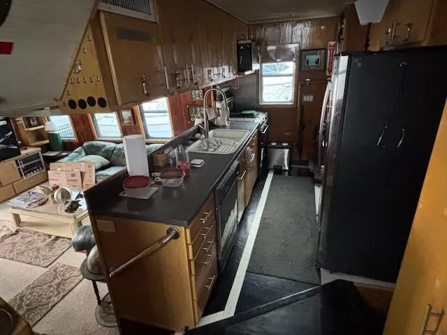 Slide: The Image of Interior of 1991 Florida Bay Coasters 53 Trawler, featuring a compact kitchen and living area. - 13