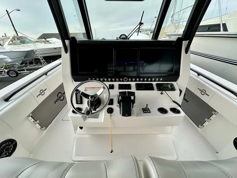 Slide: The Image of 2023 Fountain Bluewater 38 Tournament Edition boat cockpit with modern controls and steering wheel. - 6