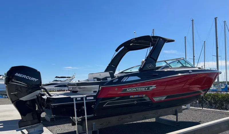 The Image of 2021 Monterey 275 Super Sport boat with Mercury engine, docked under clear blue sky. - 0