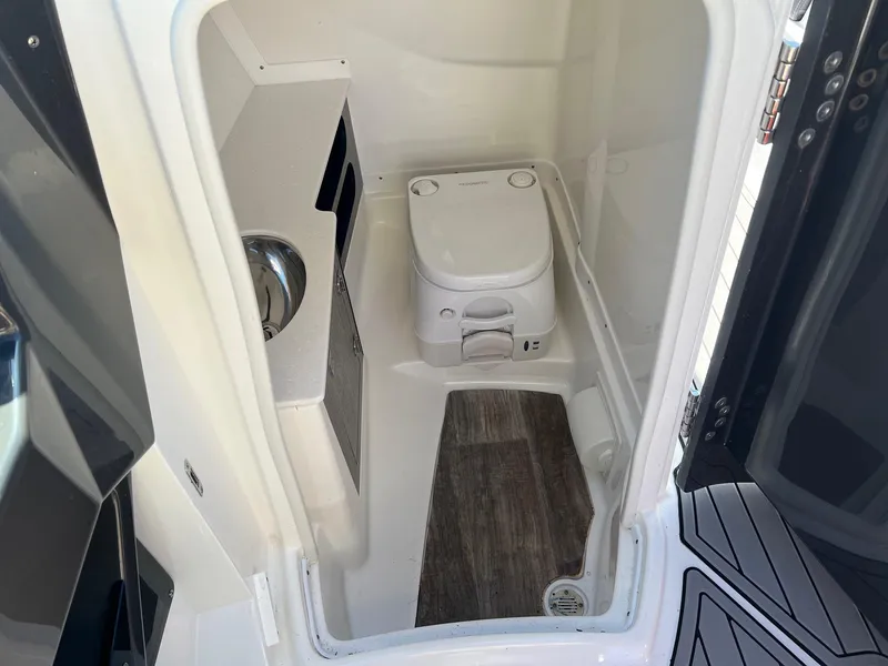 Slide: The Image of 2021 Monterey 275 Super Sport boat interior bathroom with compact toilet and sink. - 21