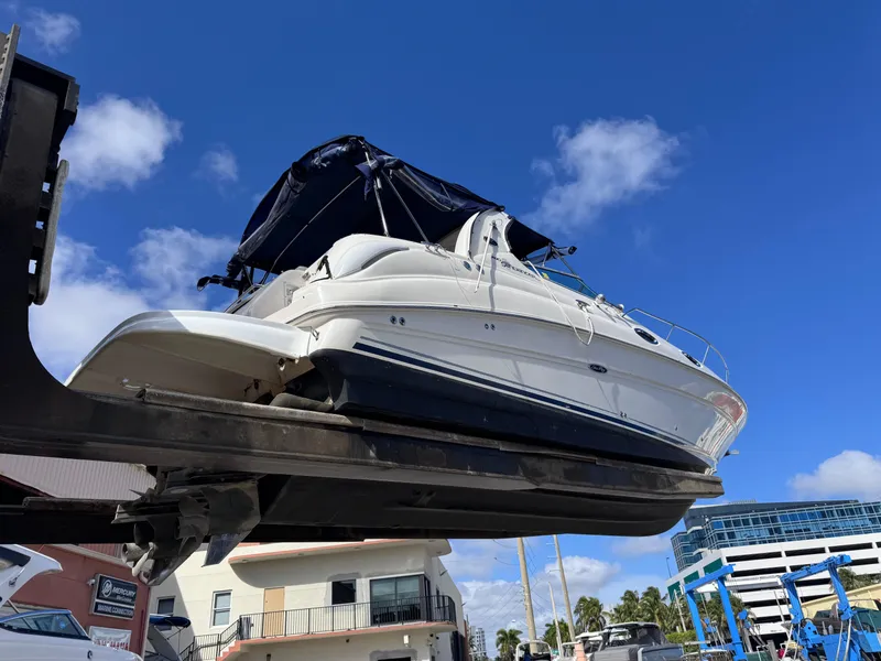 Slide: The Image of 2005 Sea Ray 280 Sundancer boat lifted, clear blue sky background. - 11