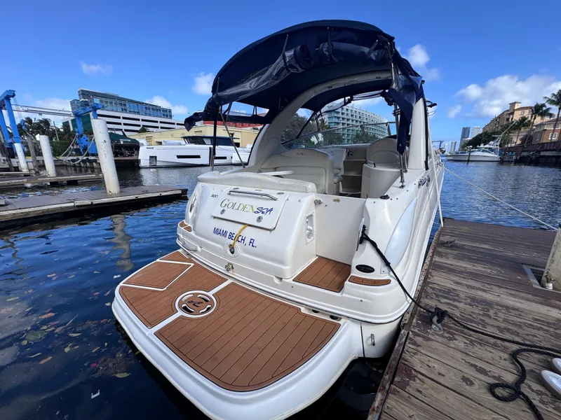Slide: The Image of 2005 Sea Ray 280 Sundancer docked at marina, featuring spacious deck and canopy. - 13