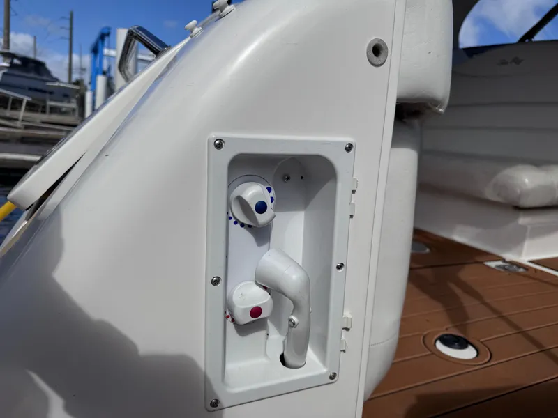 Slide: The Image of 2005 Sea Ray 280 Sundancer boat shower controls on deck, featuring hot and cold knobs. - 19