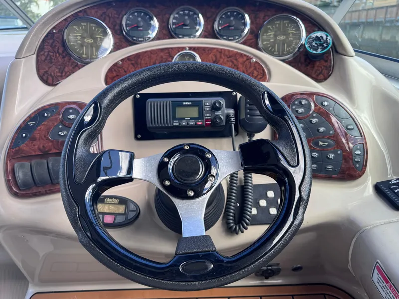 Slide: The Image of Steering wheel and dashboard of 2005 Sea Ray 280 Sundancer boat, featuring gauges and controls. - 23