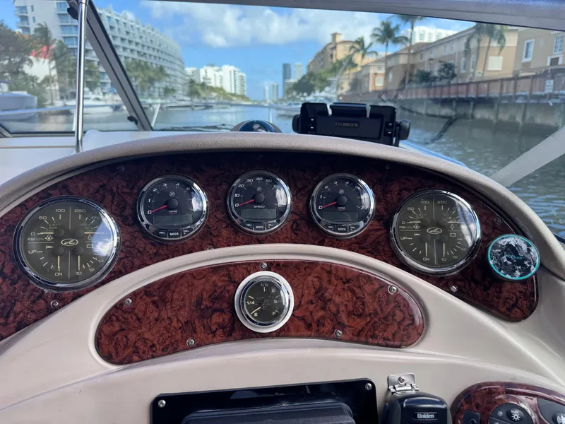 Slide: The Image of Dashboard of a 2005 Sea Ray 280 Sundancer boat with gauges and cityscape view. - 26