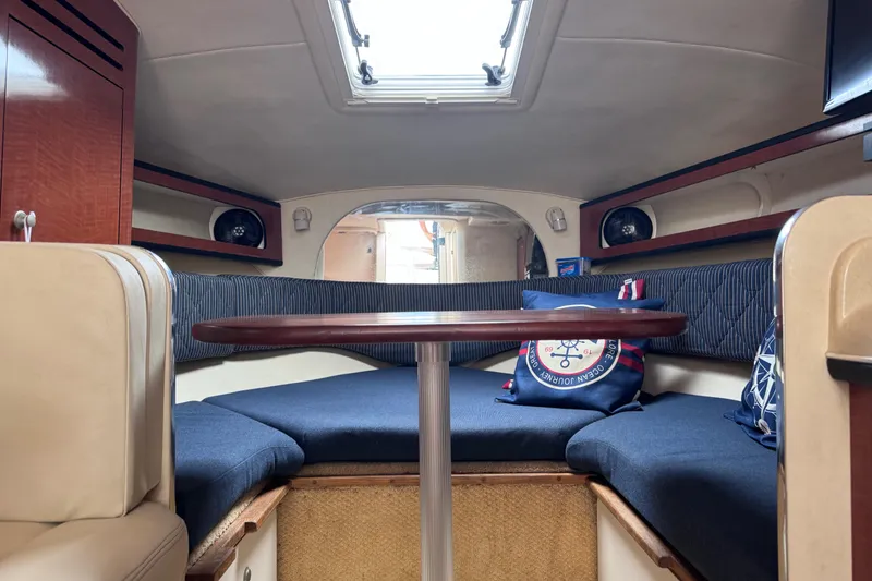 Slide: The Image of 2005 Sea Ray 280 Sundancer cabin interior with seating, table, and nautical decor. - 33