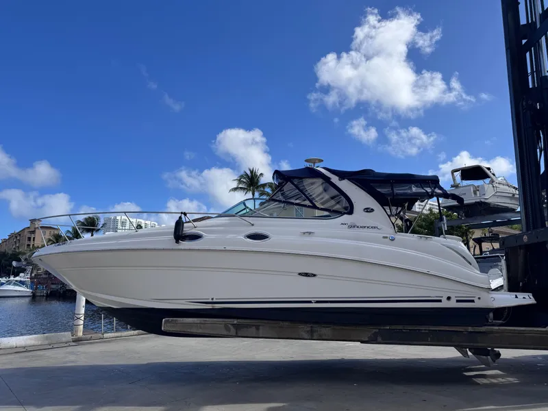 Slide: The Image of 2005 Sea Ray 280 Sundancer boat on lift, clear sky, marina background. - 4