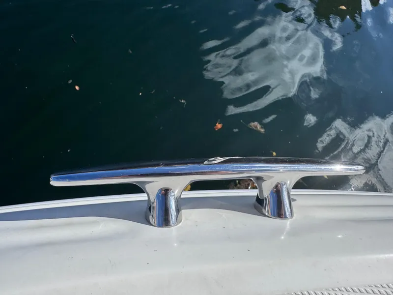 Slide: The Image of Chrome cleat on a 2005 Sea Ray 280 Sundancer, reflecting sunlight over water. - 46