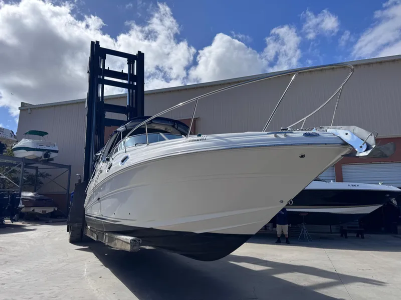 Slide: The Image of 2005 Sea Ray 280 Sundancer boat lifted by forklift under a cloudy sky. - 5