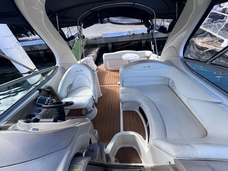 Slide: The Image of 2005 Sea Ray 280 Sundancer interior with white seating and wooden flooring. - 50
