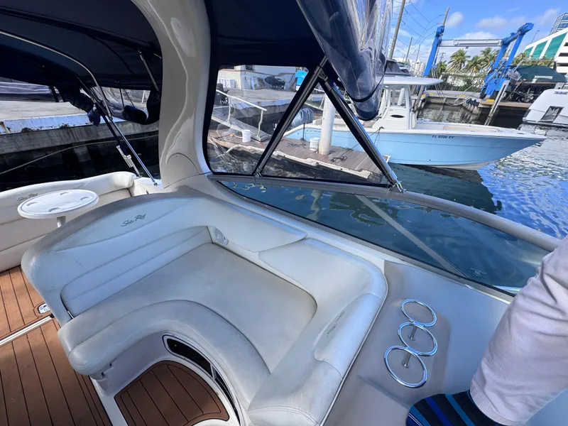 Slide: The Image of 2005 Sea Ray 280 Sundancer boat interior with white seating and wooden deck. - 52