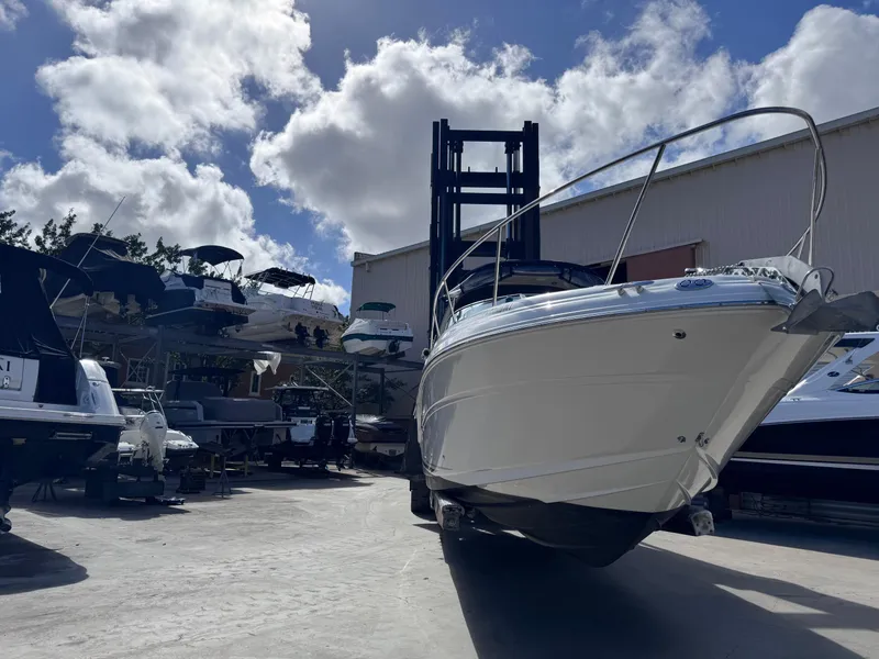 Slide: The Image of 2005 Sea Ray 280 Sundancer boat in storage yard under blue sky. - 6