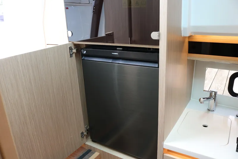 Slide: The Image of 2026 Jeanneau Leader 10.5 WA Series 2 interior with compact kitchenette and built-in refrigerator. - 22