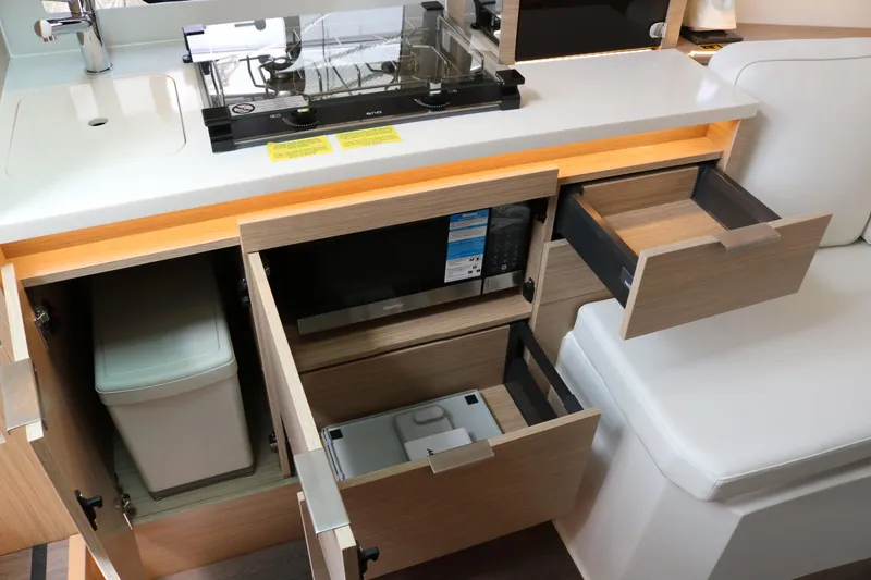 Slide: The Image of Modern kitchen area in 2026 Jeanneau Leader 10.5 WA Series 2 boat, featuring open cabinets and drawers. - 23