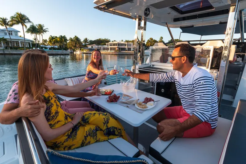 Slide: The Image of Four people enjoying a meal on a 2025 Jeanneau Leader 10.5 WA Series 2 boat. - 9