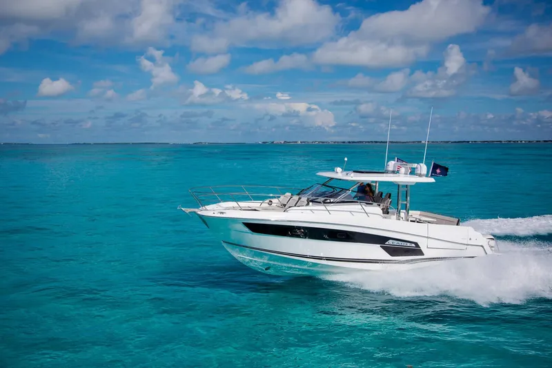 Slide: The Image of 2025 Jeanneau Leader 12.5 WA cruising on clear turquoise waters under a blue sky. - 0
