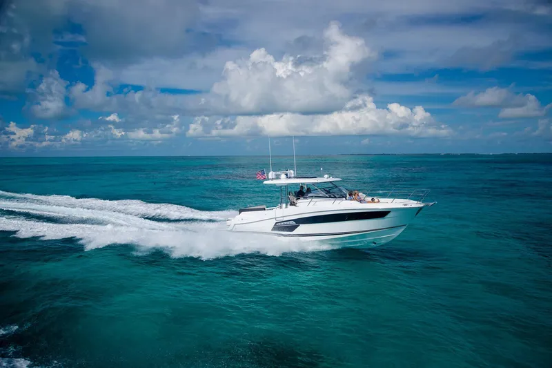 Slide: The Image of 2025 Jeanneau Leader 12.5 WA cruising on turquoise ocean under blue sky. - 1