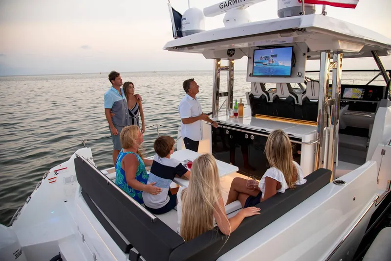 Slide: The Image of 2025 Jeanneau Leader 12.5 WA boat with people enjoying onboard entertainment. - 12