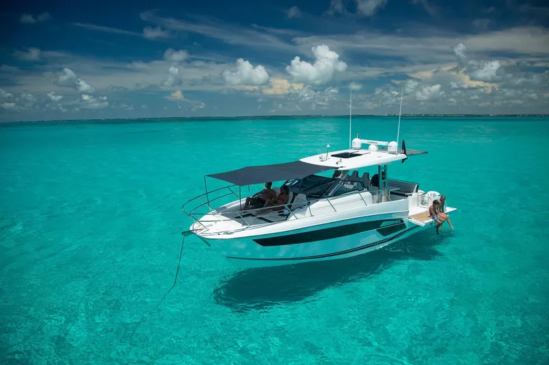 Slide: The Image of 2025 Jeanneau Leader 12.5 WA boat on clear turquoise water under blue sky. - 6