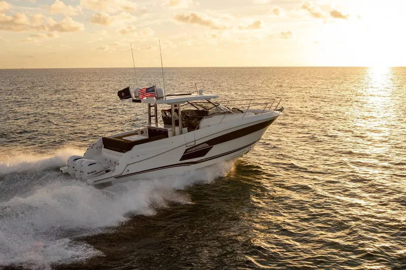Slide: The Image of 2025 Jeanneau Leader 12.5 WA cruising at sunset on open water. - 7