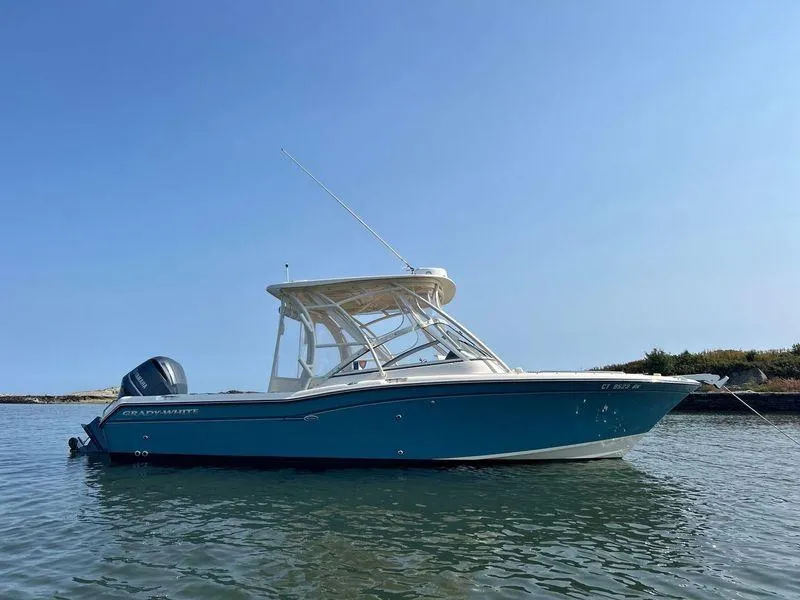 Slide: The Image of 2018 Grady-White Freedom 255 boat on calm water under clear blue sky. - 12