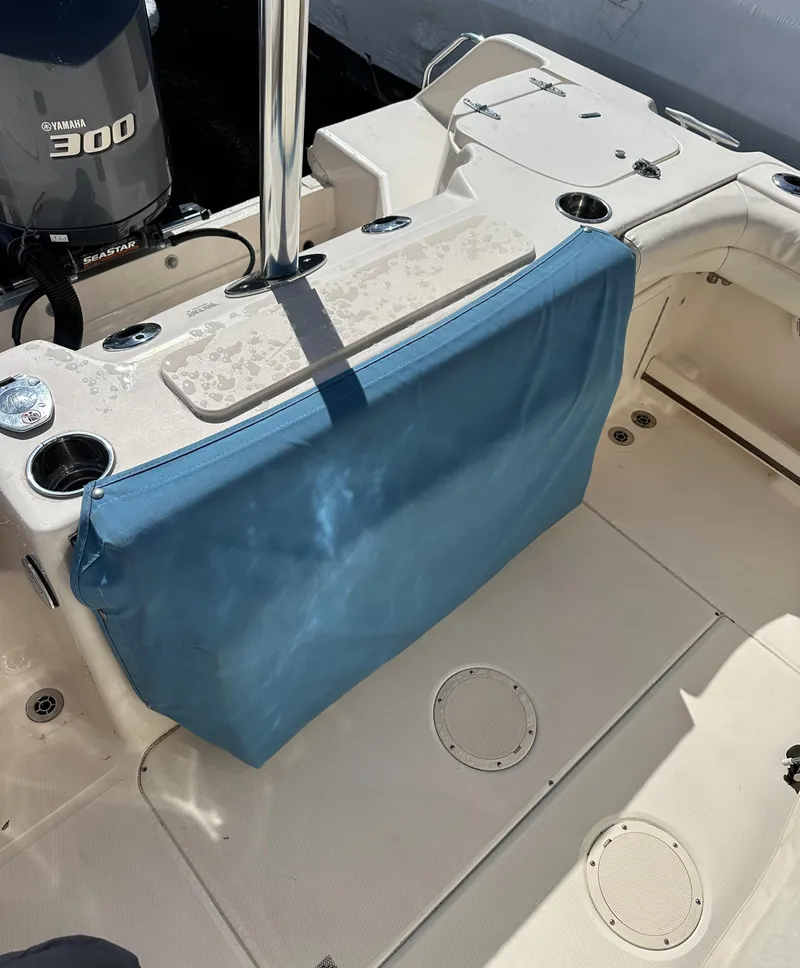 Slide: The Image of 2018 Grady-White Freedom 255 boat interior with blue cover and Yamaha 300 engine. - 14