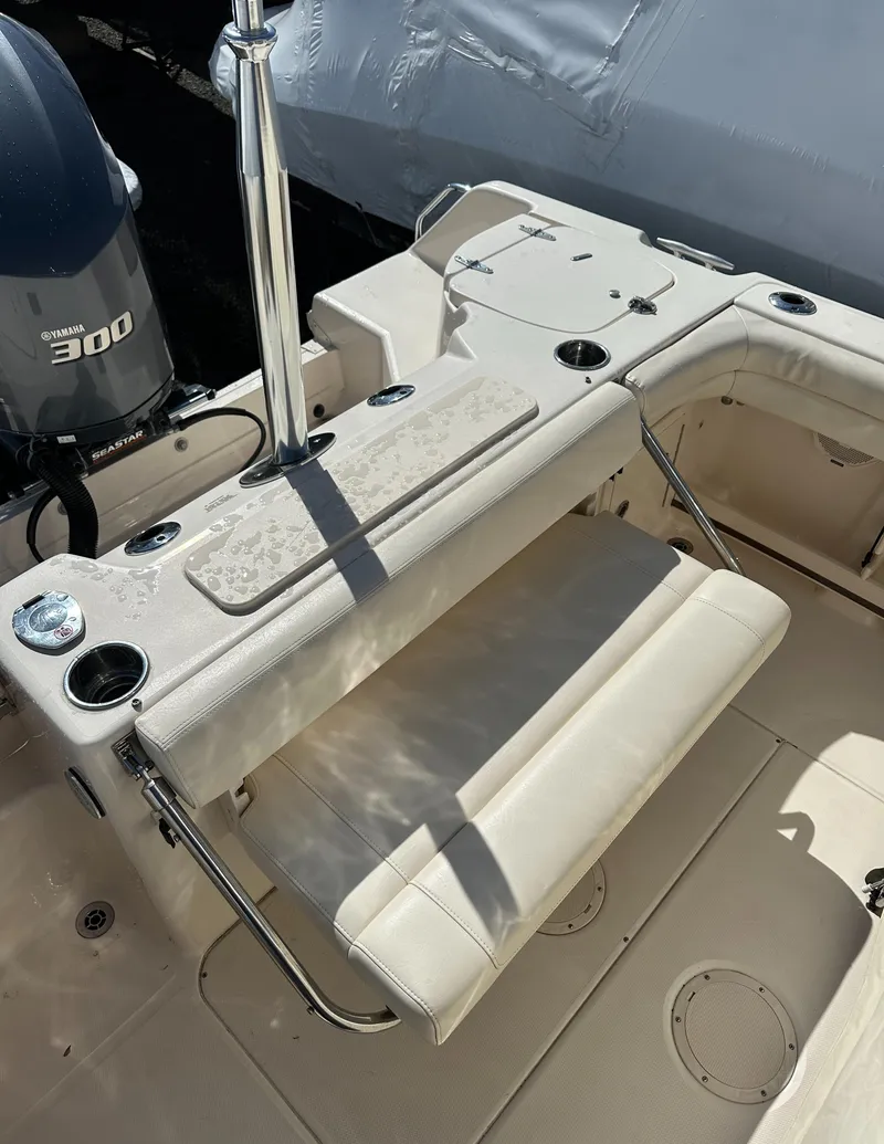 Slide: The Image of 2018 Grady-White Freedom 255 boat interior with Yamaha 300 engine, featuring seating and cup holders. - 15