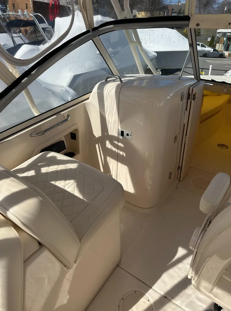 Slide: The Image of 2018 Grady-White Freedom 255 boat interior with beige seating and storage compartments. - 17