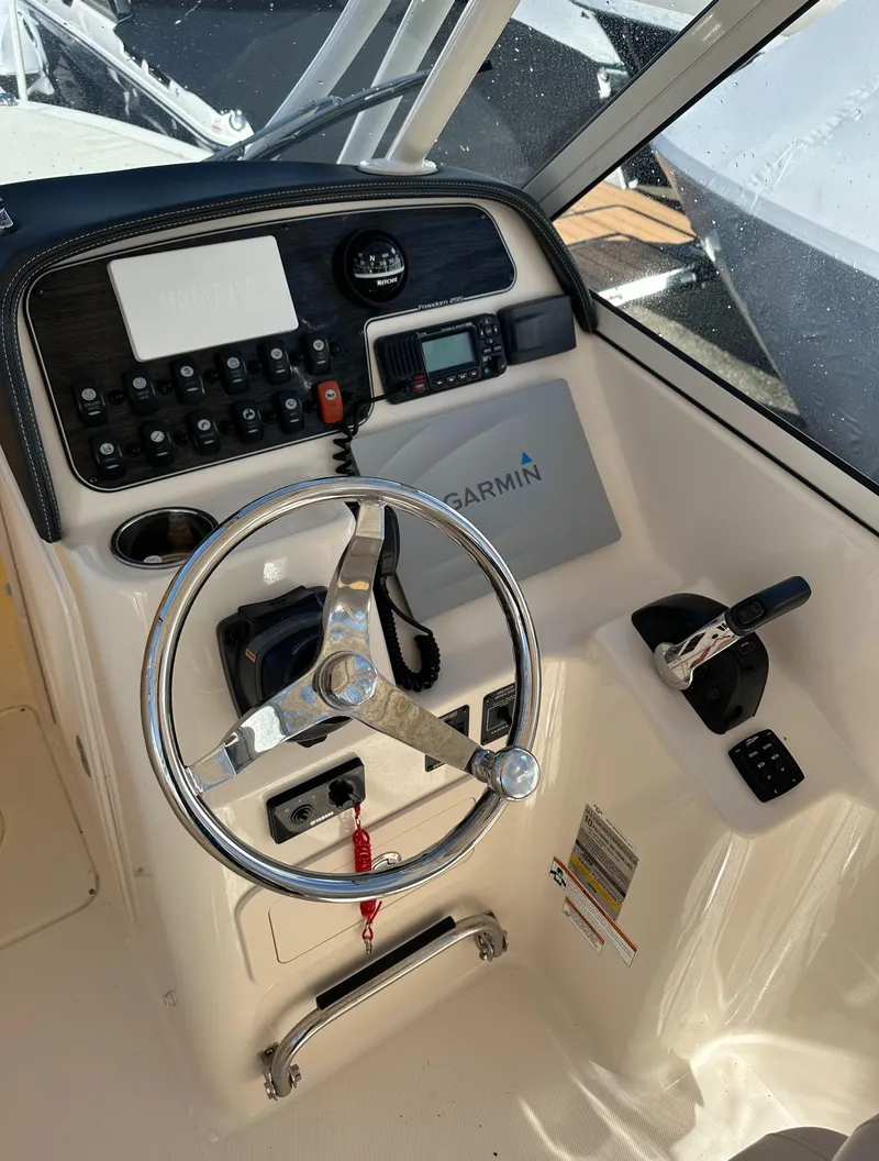 Slide: The Image of 2018 Grady-White Freedom 255 boat helm with Garmin navigation system and steering wheel. - 19