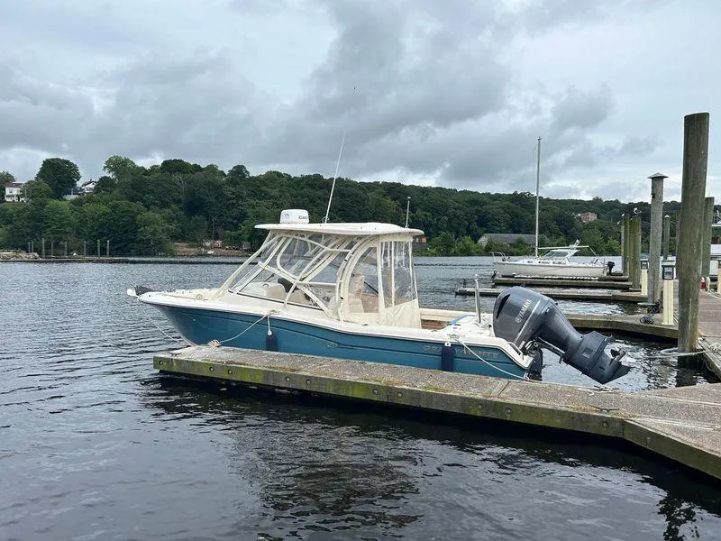 Slide: The Image of 2018 Grady-White Freedom 255 boat docked on a calm lake under cloudy skies. - 25