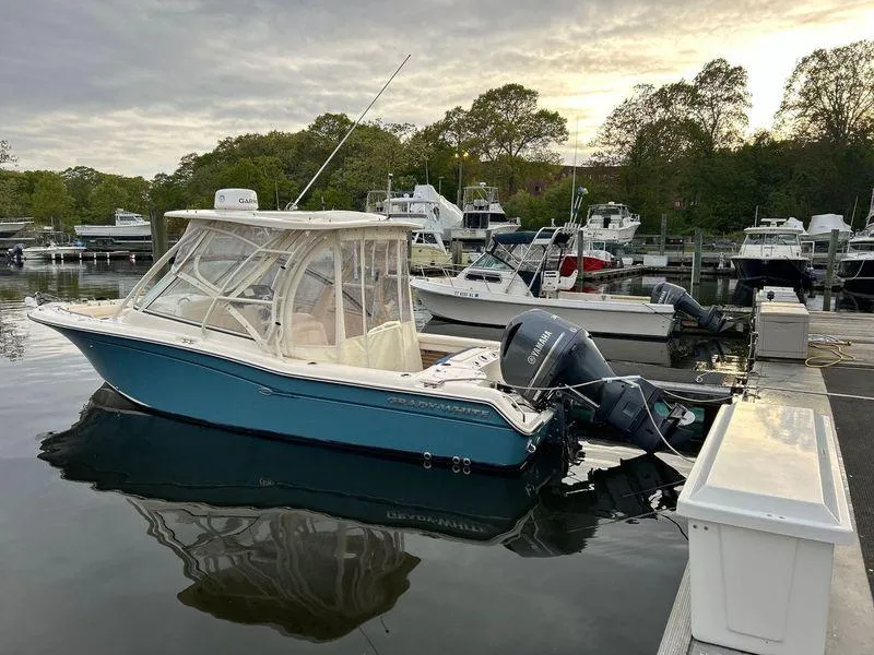 Slide: The Image of 2018 Grady-White Freedom 255 boat docked in a serene marina setting. - 26