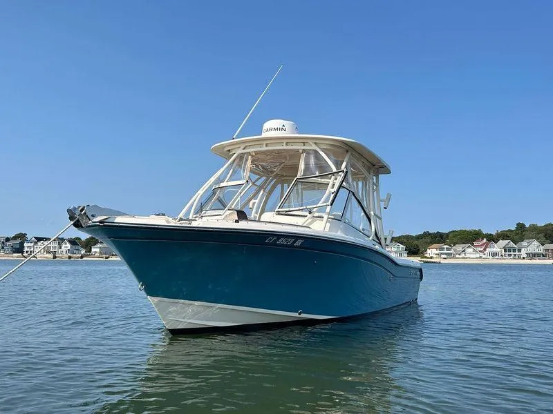 Slide: The Image of 2018 Grady-White Freedom 255 boat on calm water, clear sky background. - 3