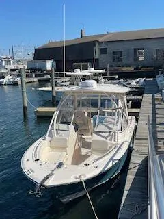 Slide: The Image of 2018 Grady-White Freedom 255 docked at a marina under clear blue skies. - 30