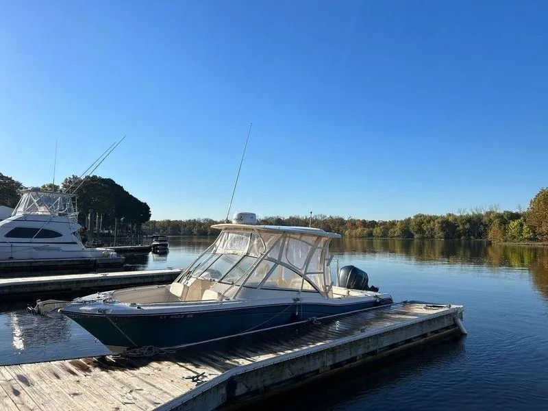 Slide: The Image of 2018 Grady-White Freedom 255 boat docked on a serene lake under clear blue skies. - 31