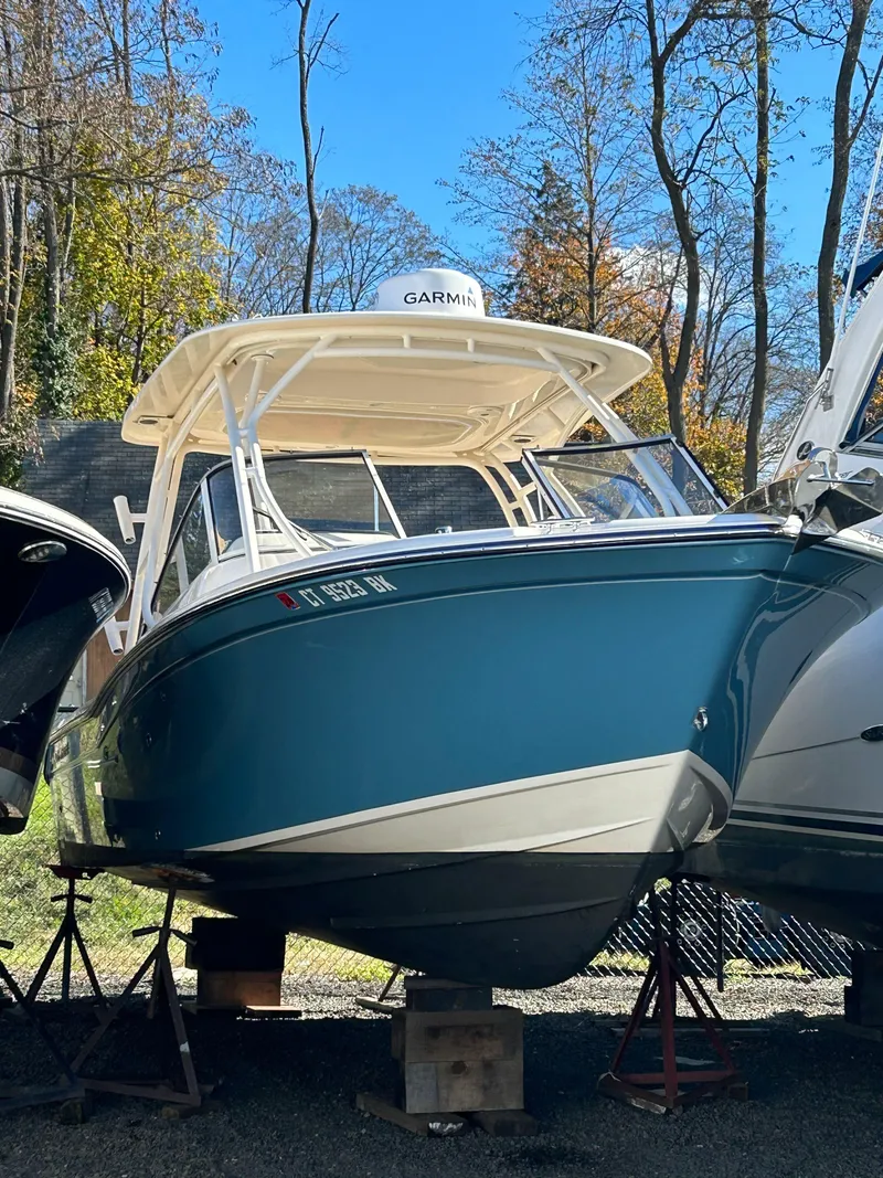 Slide: The Image of 2018 Grady-White Freedom 255 boat on stands, surrounded by trees. - 35