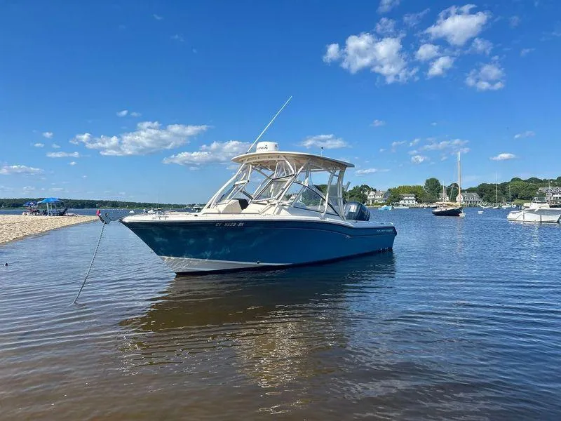 Slide: The Image of 2018 Grady-White Freedom 255 boat anchored in calm waters under a clear blue sky. - 4