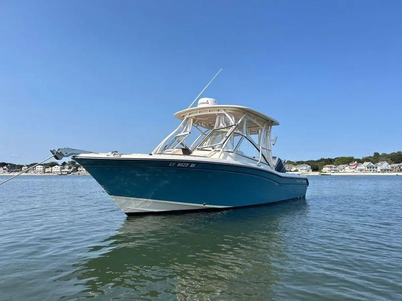 Slide: The Image of 2018 Grady-White Freedom 255 boat on calm water under clear blue sky. - 5