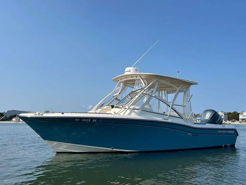 Slide: The Image of 2018 Grady-White Freedom 255 boat on calm water under clear blue sky. - 6