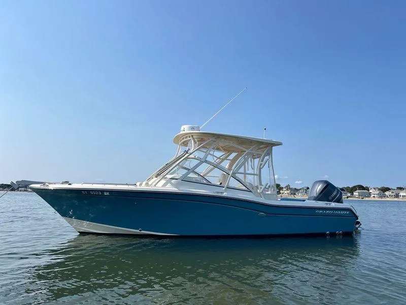 Slide: The Image of 2018 Grady-White Freedom 255 boat on calm water under clear blue sky. - 7