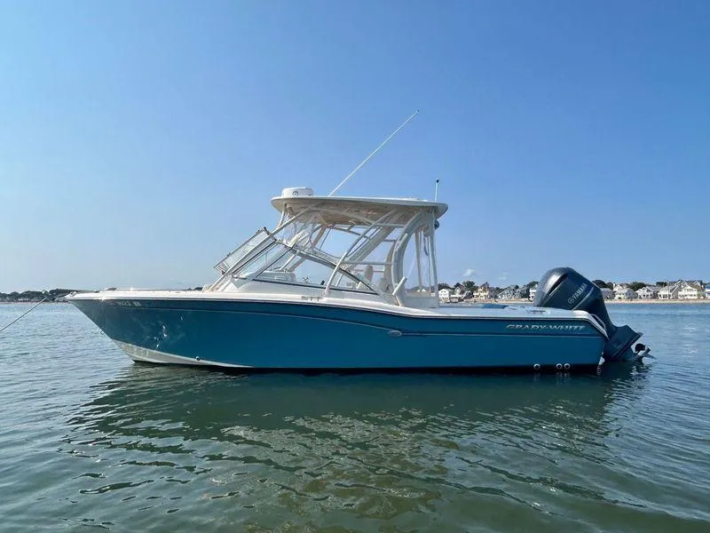 Slide: The Image of 2018 Grady-White Freedom 255 boat on calm water, clear blue sky background. - 8