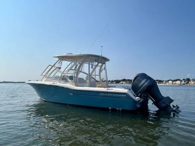 Slide: The Image of 2018 Grady-White Freedom 255 boat on calm water, clear sky background. - 9