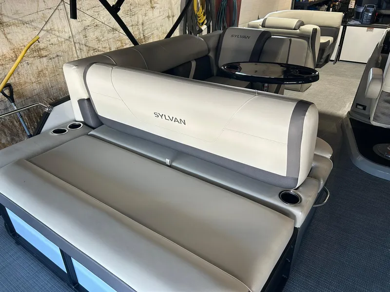 Slide: The Image of 2025 Sylvan Mirage X X3 CLZ boat interior with plush seating and cup holders. - 14