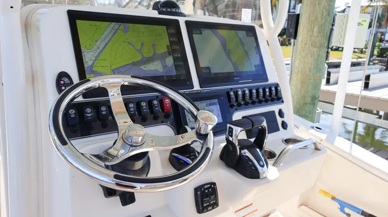 Slide: The Image of 2023 Grady-White 281 Coastal Explorer dashboard with navigation screens and steering wheel. - 20