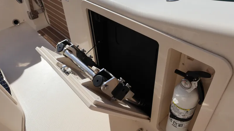 Slide: The Image of 2023 Grady-White 281 Coastal Explorer boat compartment with fire extinguisher and storage space. - 26
