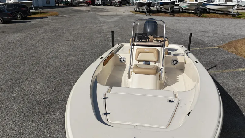 Slide: The Image of 2022 Scout 177 Sport boat, beige interior, parked on asphalt, surrounded by other boats. - 4