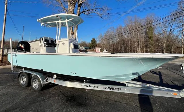 Slide: The Image of 2024 Tidewater 2300 Carolina Bay boat on trailer, parked outdoors. - 2