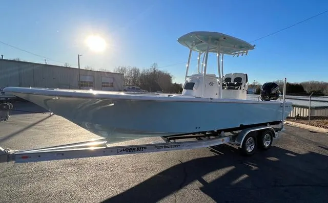 Slide: The Image of 2024 Tidewater 2300 Carolina Bay boat on trailer, parked outdoors under clear sky. - 7