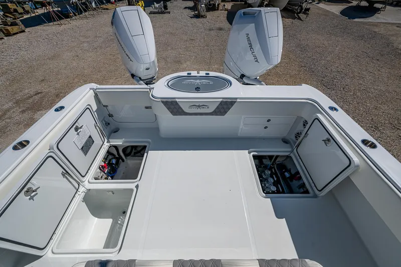 Slide: The Image of 2025 Invincible 33 Catamaran with open storage compartments and dual Mercury outboard engines. - 14
